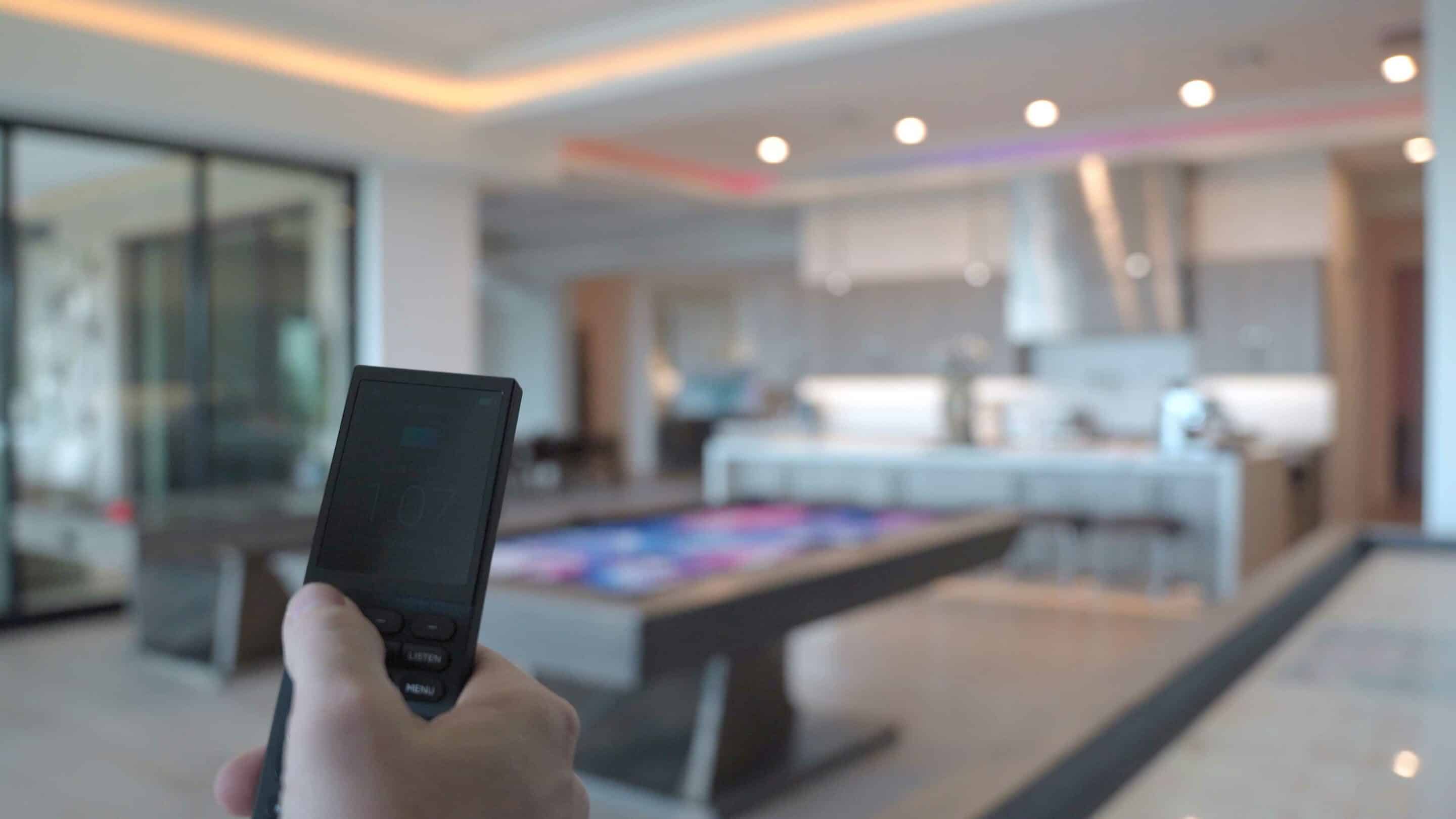 Nate hold remote control to control lighting in Mesa Smart Home